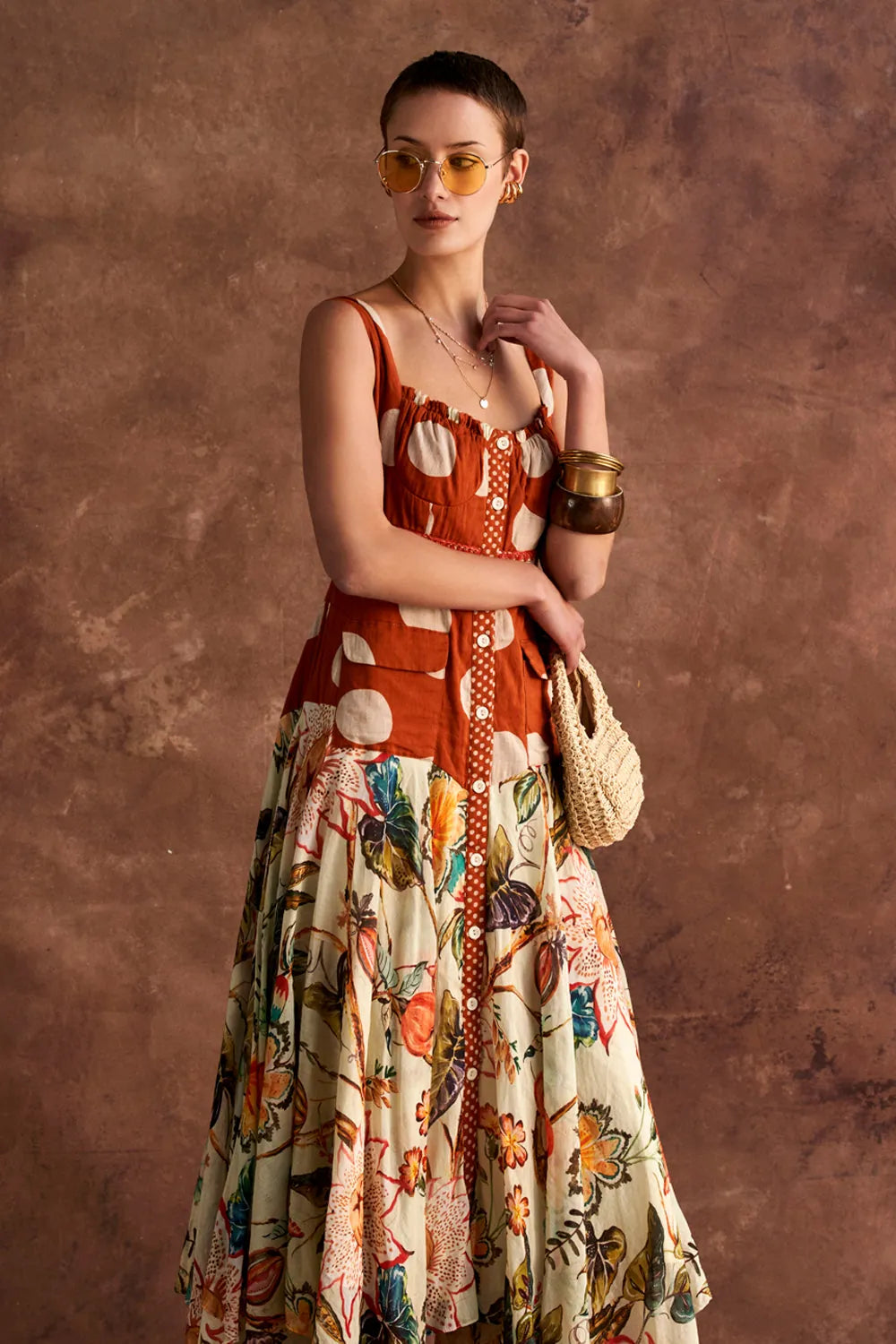 Woman wearing a colorful dress with a patterned design against a brown textured background
