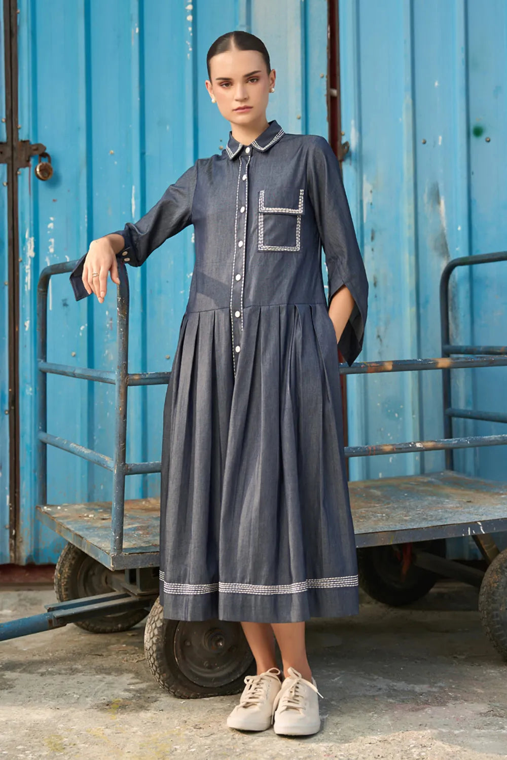 Elma Dress women's dark blue chambray midi dress featuring a structured shirt collar, button-down front, three-quarter sleeves with buttoned cuffs, a statement chest pocket with contrast stitching and a softly pleated skirt, styled for work meetings, casual outings and day-to-evening occasions.