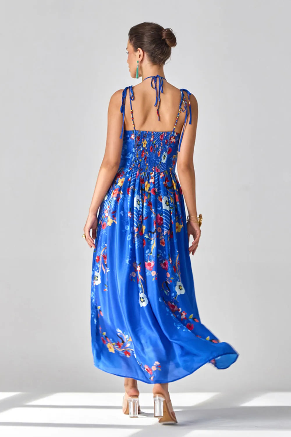 Back view of Isla Spaghetti Dress women's blue satin chiffon maxi dress featuring delicate spaghetti straps, a sleek flowing silhouette and minimal elegant styling, designed for resort evenings, intimate dinners, summer holidays and destination celebrations.