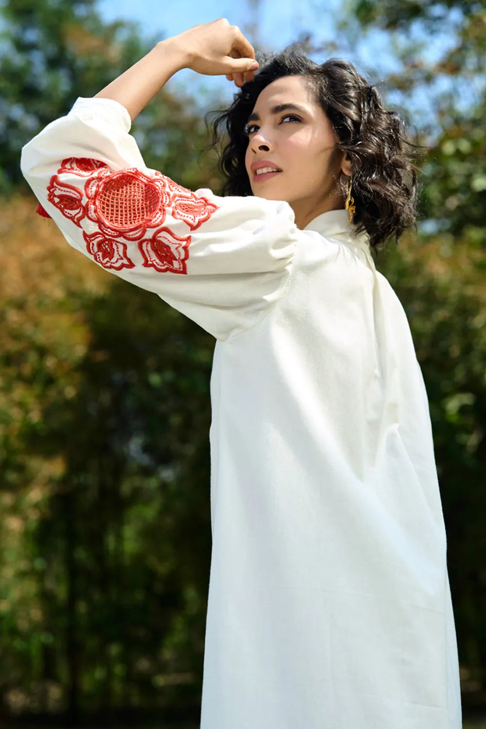 Closeup look of Ivar Embroidered Dress women's ivory cotton midi dress featuring intricate pearl cutwork embroidery on the sleeves, a relaxed silhouette and elegant handcrafted detailing, styled for summer brunches, daytime celebrations, garden gatherings and sophisticated casual occasions.