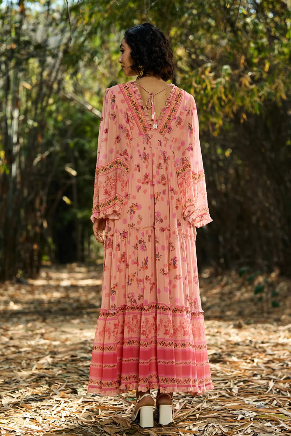 Back view of Joly Embroidered Maxi Dress women's peach and pink viscose georgette maxi dress featuring a playful printed design, V-neckline, beaded embroidered neckline and adjustable smocked waist, styled for weddings, summer holidays, resort dinners and special occasions.