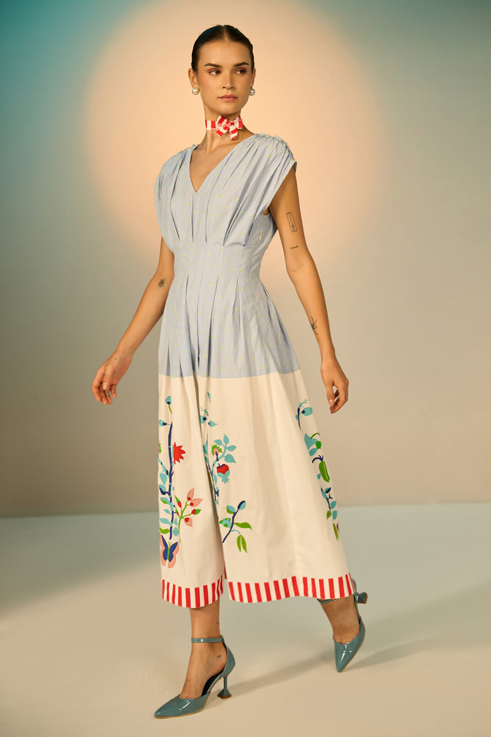 Woman wearing a two-tone dress with floral patterns on a neutral background