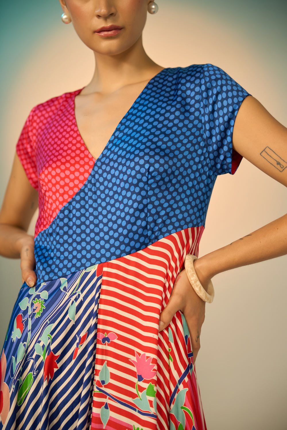 Woman wearing a colorful patterned dress with a neutral background
