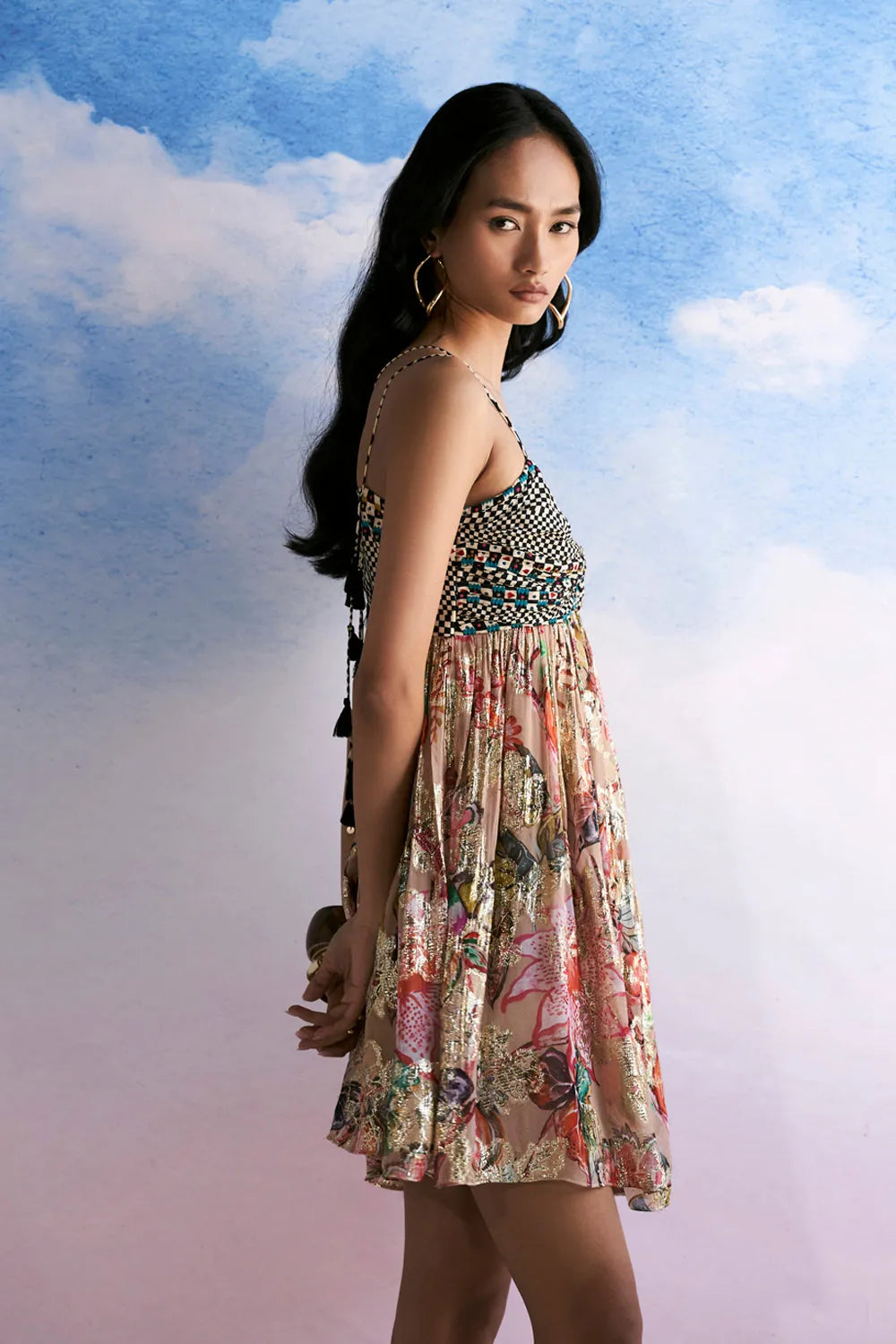Side view of Anvena Lily dress showing its fitted embellished bodice, flowing floral skirt and relaxed flared silhouette