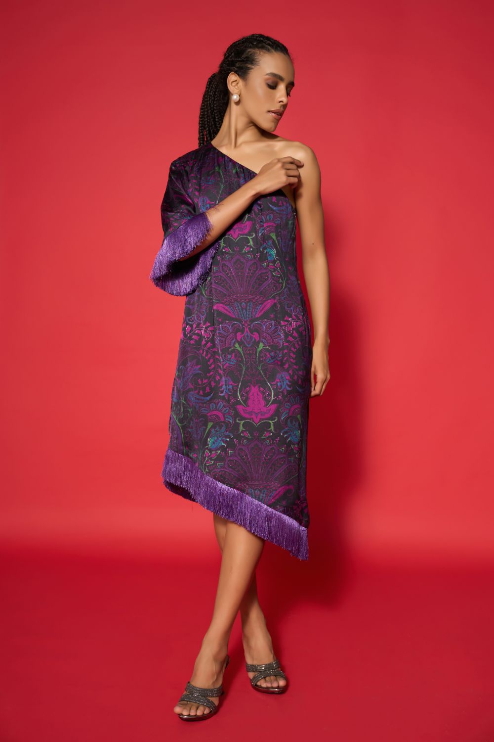 Woman wearing a purple embroidered dress against a red background