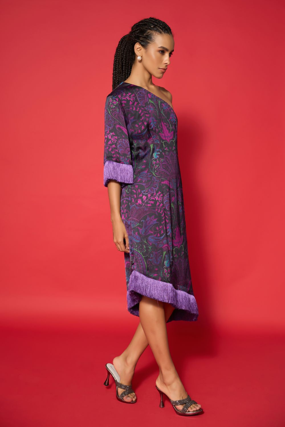 Woman wearing a purple dress with floral patterns against a red background