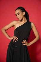 Woman wearing a black one-shoulder dress against a red background