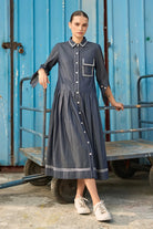 Elma Dress women's dark blue chambray midi dress featuring a structured shirt collar, button-down front, three-quarter sleeves with buttoned cuffs, a statement chest pocket with contrast stitching and a softly pleated skirt, styled for work meetings, casual outings and day-to-evening occasions.