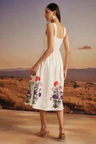Back view of Emery Dress women's beige cotton dress featuring a sweetheart neckline, delicate bead detailing and a floral print with a feminine 50-inch silhouette, styled for summer brunches, resort vacations, garden parties and special occasions.