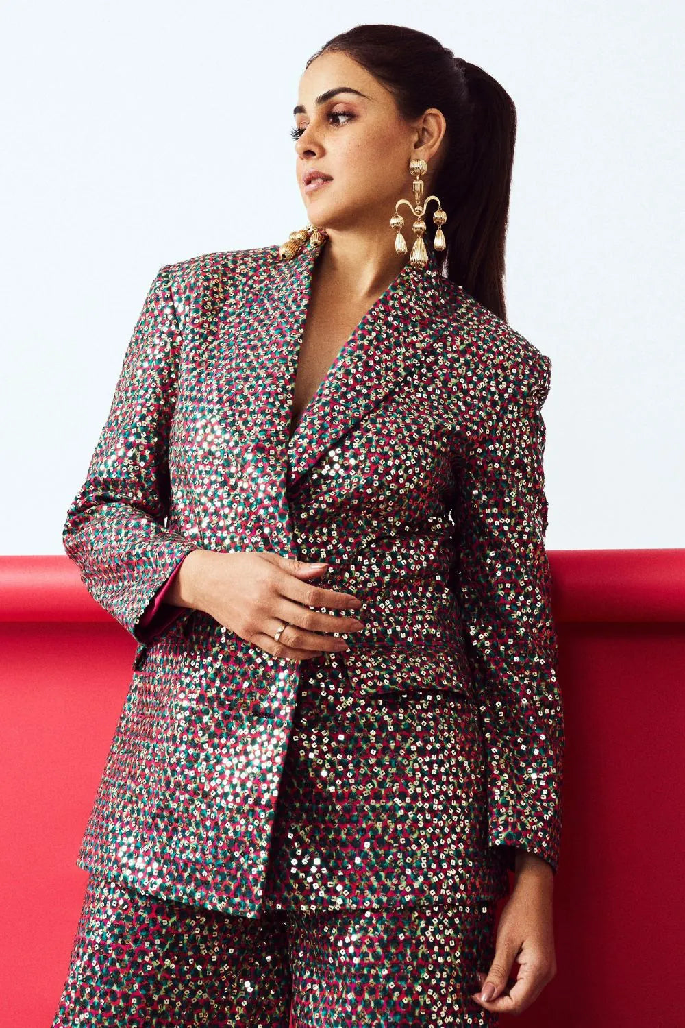 Woman wearing a patterned suit against a red and white background