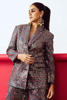 Woman wearing a patterned suit against a red and white background