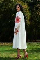 Back view of Ivar Embroidered Dress women's ivory cotton midi dress featuring intricate pearl cutwork embroidery on the sleeves, a relaxed silhouette and elegant handcrafted detailing, styled for summer brunches, daytime celebrations, garden gatherings and sophisticated casual occasions.