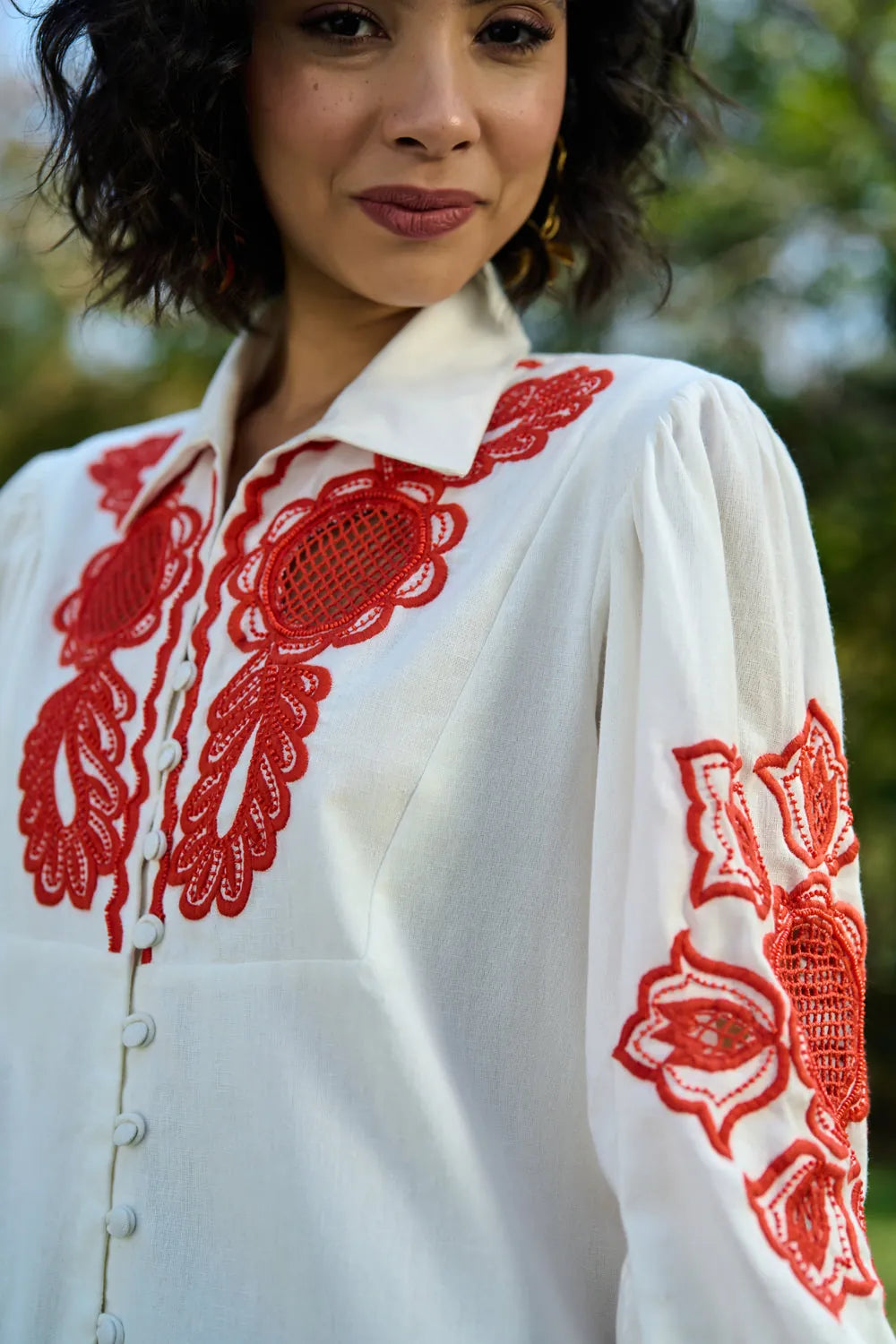 Detail's view of Ivar Embroidered Dress women's ivory cotton midi dress featuring intricate pearl cutwork embroidery on the sleeves, a relaxed silhouette and elegant handcrafted detailing, styled for summer brunches, daytime celebrations, garden gatherings and sophisticated casual occasions.