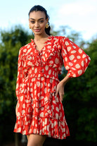 Woman wearing a red dress with white polka dots outdoors