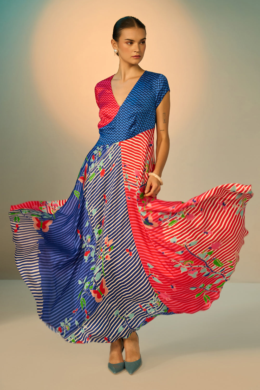 Woman wearing a colorful dress with a patterned design on a neutral background