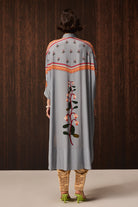 back view of Kori Embroidered Shirt With Pants women's pale blue Double Georgette co-ord set featuring an oversized shirt with tonal embroidery and matching newspaper-print jogger pants, combining a relaxed silhouette with an artistic statement design, styled for airport looks, resort lounging, travel days and casual outings.