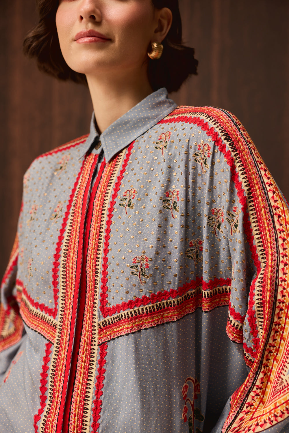 Closeup look of Kori Embroidered Shirt With Pants women's pale blue Double Georgette co-ord set featuring an oversized shirt with tonal embroidery and matching newspaper-print jogger pants, combining a relaxed silhouette with an artistic statement design, styled for airport looks, resort lounging, travel days and casual outings.