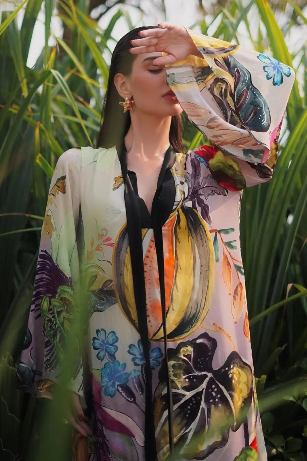 Closeup look of Rawan Bin Hussain wearing the Jianna Dress, a women's multicolour double georgette maxi dress featuring a vibrant mixed print, dramatic flared sleeves and a flowing floor-length silhouette, styled for resort vacations, summer celebrations, destination dinners and elegant daytime occasions.