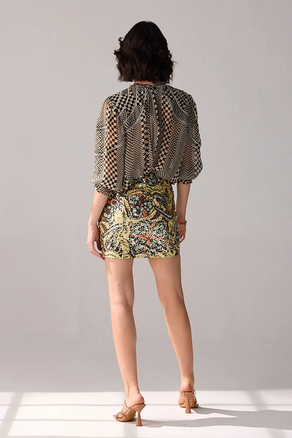 Back view of Aria multicolour floral mini skirt featuring a fitted silhouette and intricate botanical print