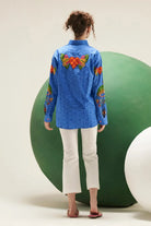 Back view of Arin cobalt blue cotton shirt showing its relaxed silhouette, long sleeves and colourful embroidered detailing