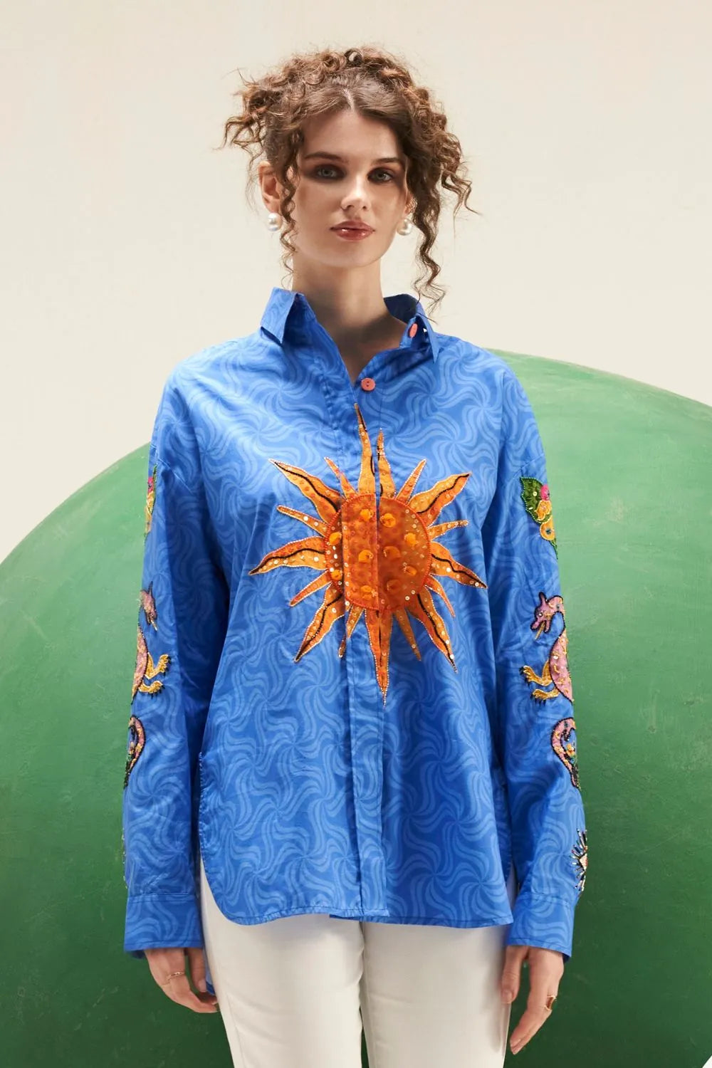 Arin cobalt blue cotton shirt featuring a relaxed fit, button-down front, long sleeves and a bold embroidered orange sun motif across the chest