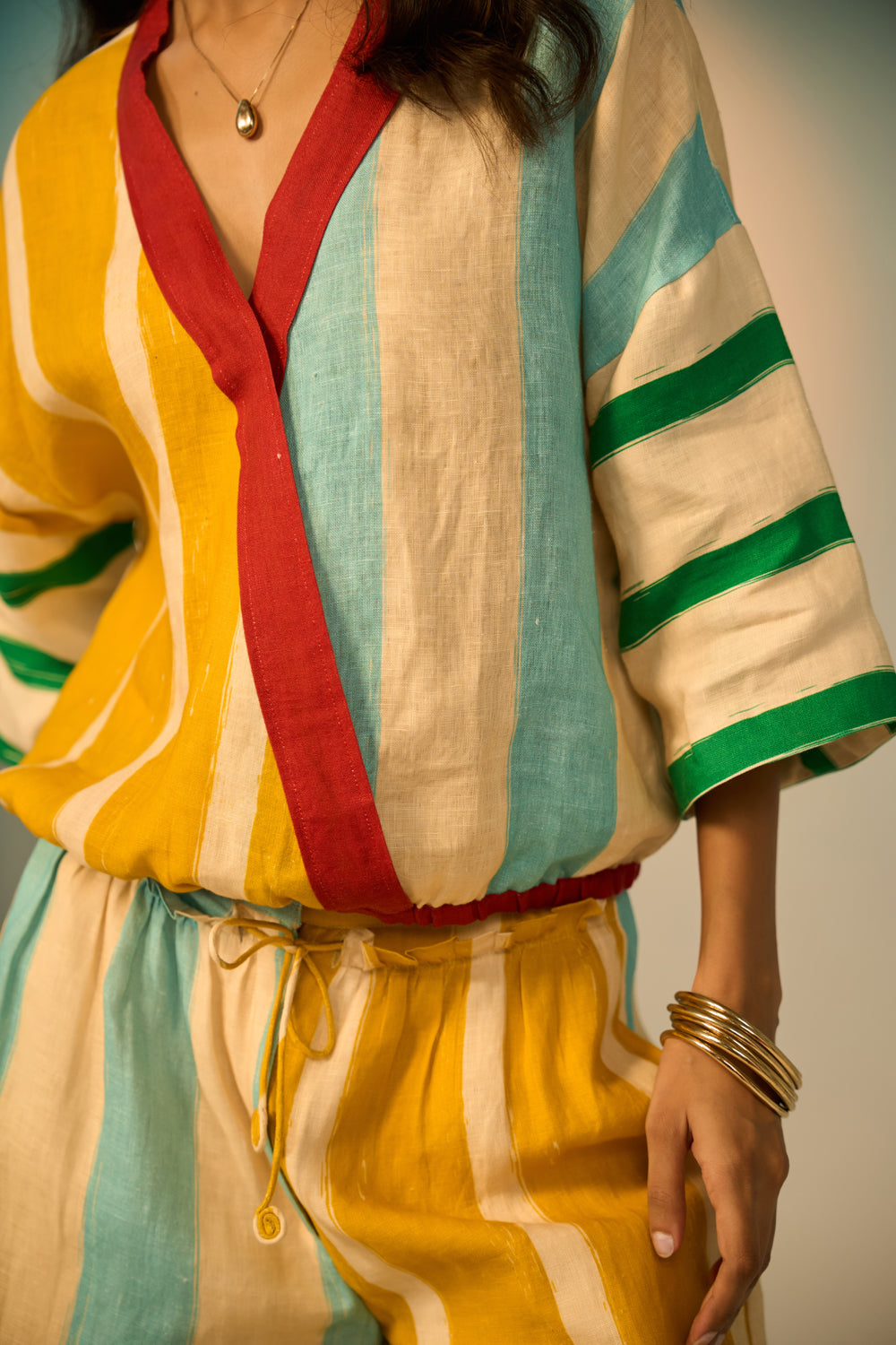 Colorful striped outfit with a focus on a sleeveless top and pants.