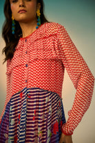 A close-up look of a woman wearing a red and blue striped dress with a clean background