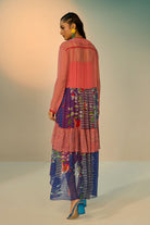 Back view of a woman wearing a red and blue striped dress with a clean background