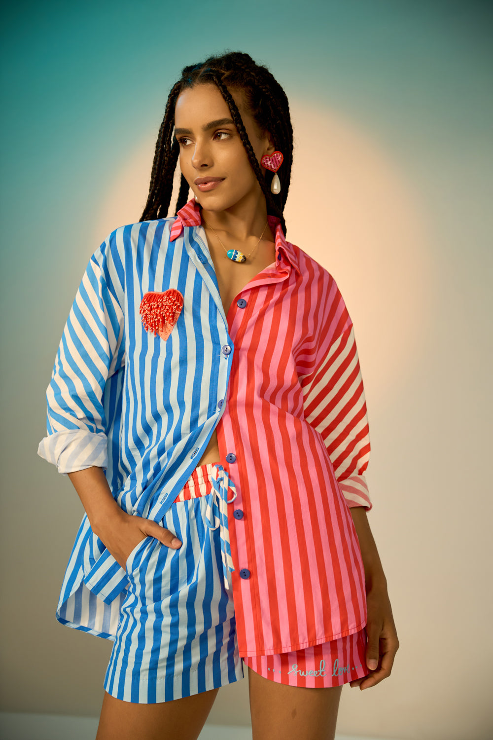 Woman wearing a colorful co-ord set with a blue and pink striped shirt and shorts.